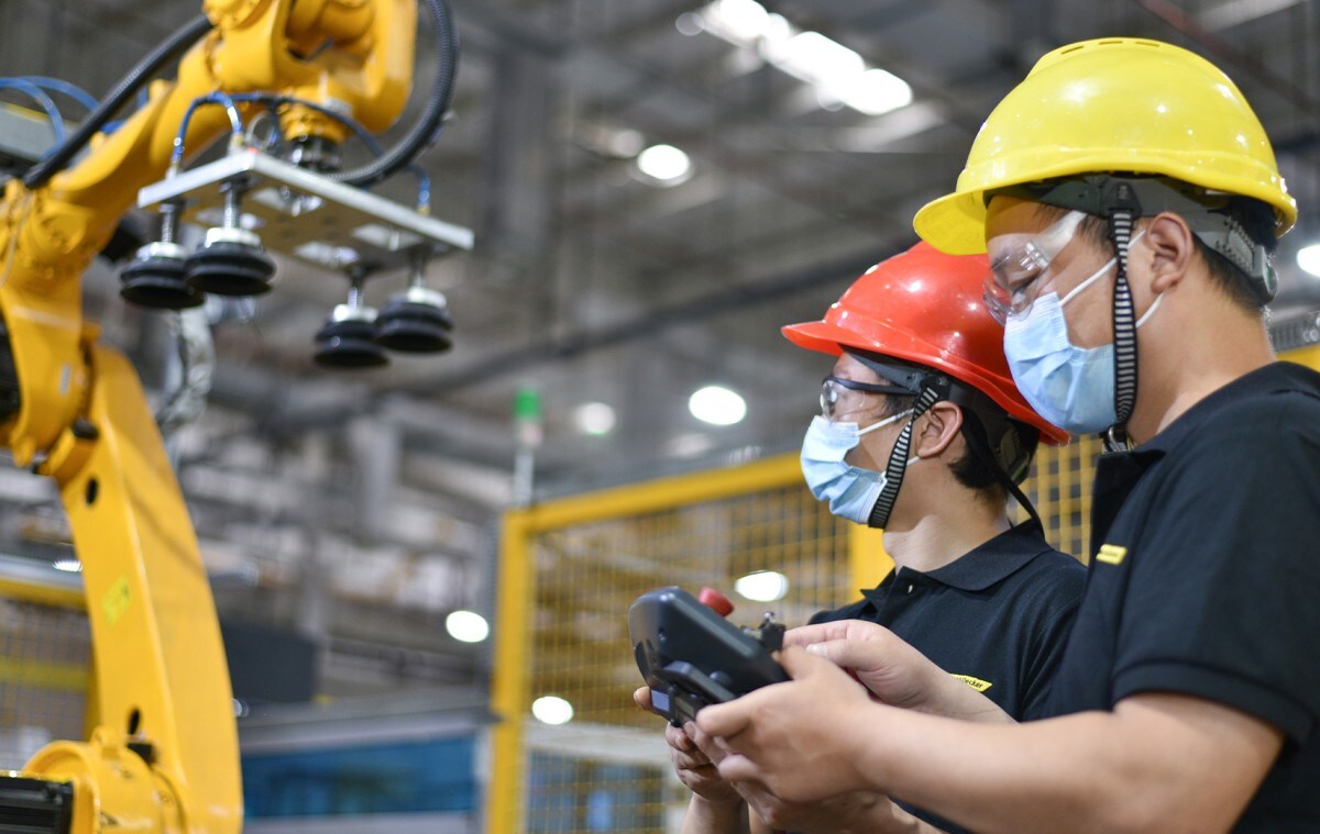 史丹利百得的两名员工在工厂里使用合作机器人